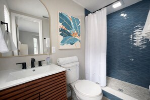 A bathroom with a white sink, black faucets, a toilet, and a shower curtain. - Paradise - Golf Cart Rental, Kayaks, Paddle Boat, Fishing & Swimming (Hernando Beach)