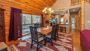 L’intérieur d’un chalet en bois comprend un coin repas, une cuisine et un escalier.
