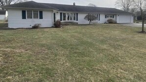 A single-story house with a front porch, a garage, and a small front yard.