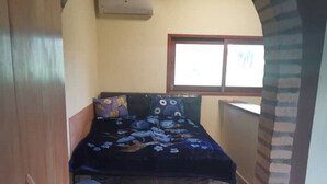Una camera da letto con un letto, una finestra e una porta.