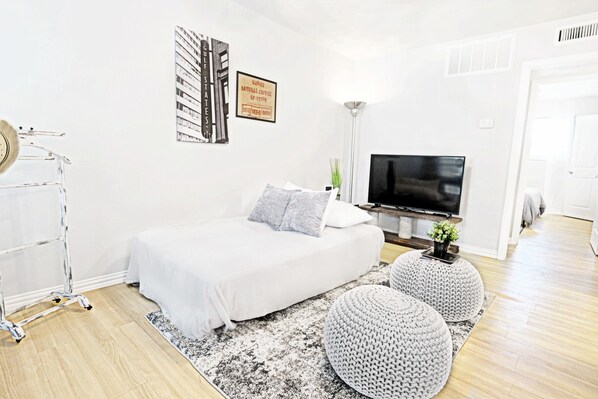 A modern bedroom with a bed, a TV, and a coffee table.