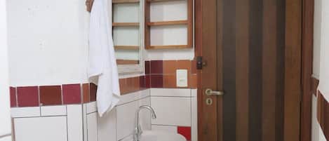 Un baño pequeño con lavamanos, espejo y retrete.