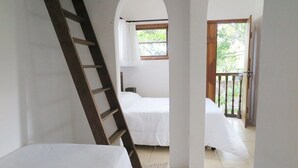 A bedroom with a ladder leaning against the wall, a bed, and a window with curtains. - Pousart Floripa (Florianópolis)