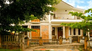 A two-story house with a brick facade, a balcony, and a gated entrance. - Pousart Floripa (Florianópolis)
