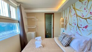 A bedroom with a bed, a window with curtains, a wall-mounted shelf, and a door. - Sabatico Beach House (Búzios)