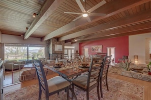 A spacious dining area with a large wooden table set for a meal, surrounded by chairs. - Spacious bohemian canyon home with views (Reno)