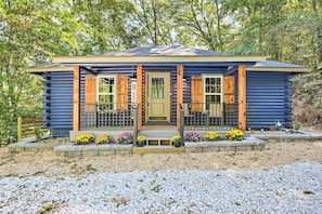 A small, single-story cabin with a front porch, wooden shutters, and a welcome sign. - Secluded Table Rock Lake/Branson Cabin w/ Hot Tub! (Kimberling City)