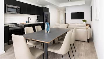A modern kitchen with black cabinets, a stainless steel microwave, and a built-in oven.