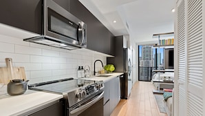 A modern kitchen with stainless steel appliances, white tiles, and a view of the city through the window. - The Elser Hotel Miami (Miami)