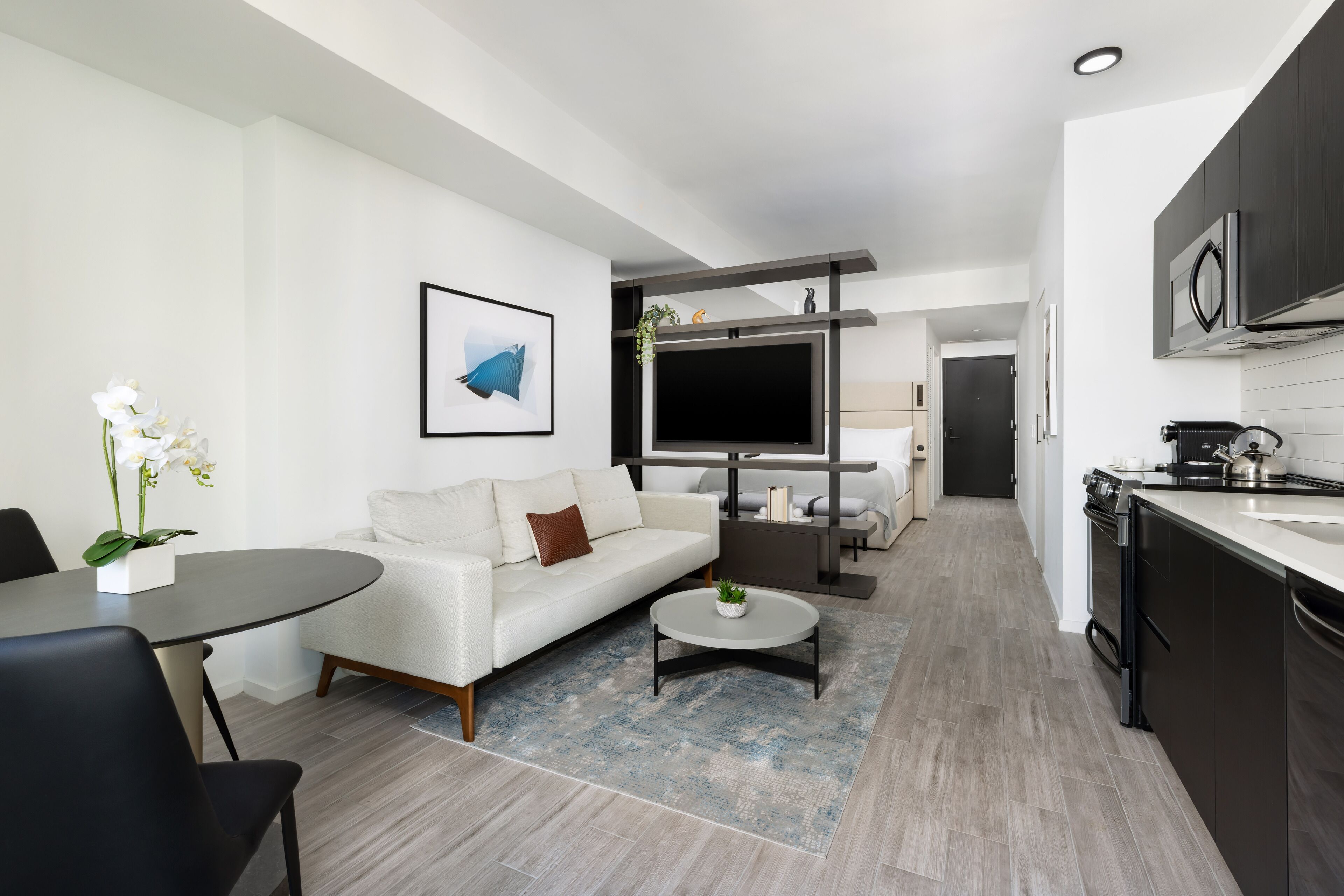 A modern living room with a sofa, coffee table, and a TV.