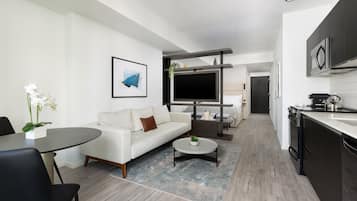 A modern living room with a sofa, coffee table, and a TV.