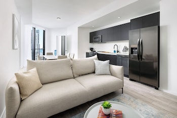 A modern gym with various exercise equipment, large windows offering city views, and a staircase leading to an upper level. at The Elser Hotel Miami