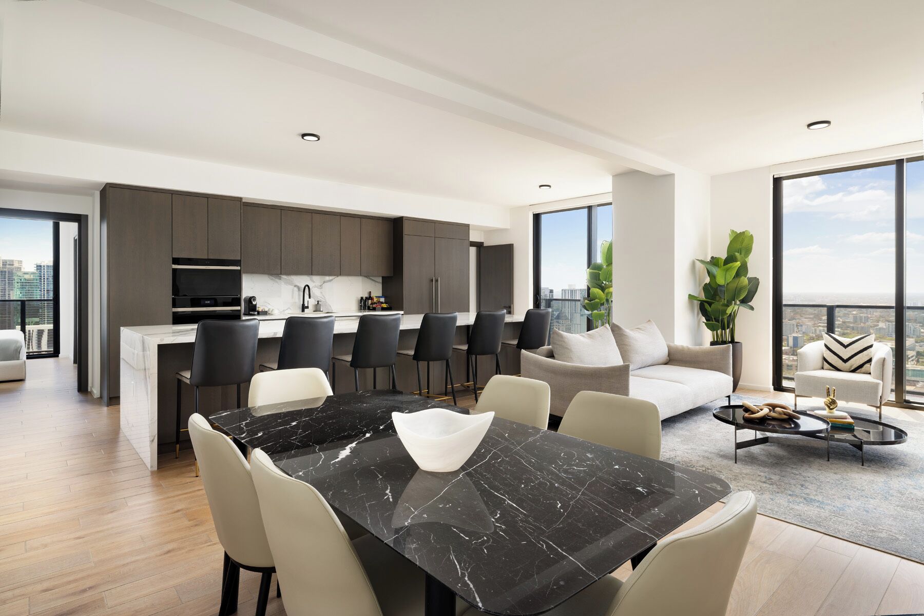 Un apartamento moderno con comedor, cocina y zona de estar con vistas a la ciudad.