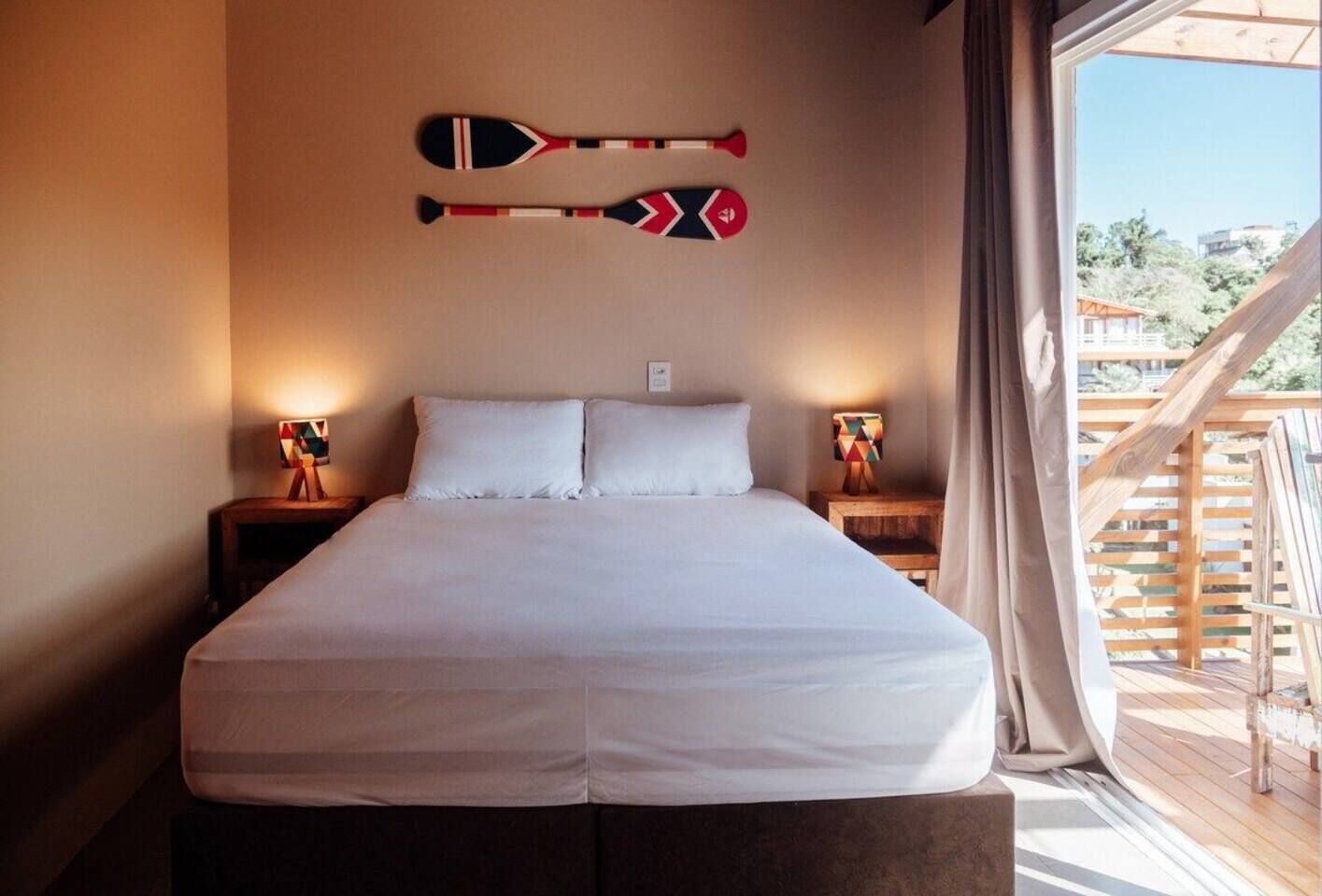 Een slaapkamer met een groot bed, twee nachtkastjes en uitzicht op de omgeving.