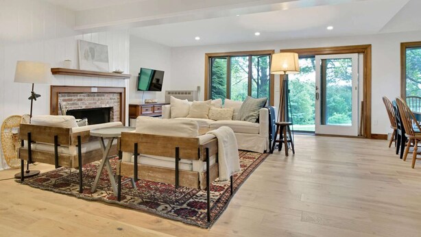 Una amplia sala de estar con chimenea, un sofá, una mesa de centro y un televisor.