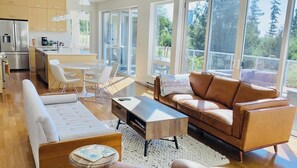 Enjoy a spacious living area with a sleek kitchen, comfortable seating, and a large dining table.