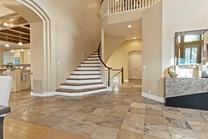 Stunning interior with a grand staircase, dining area, and modern kitchen.