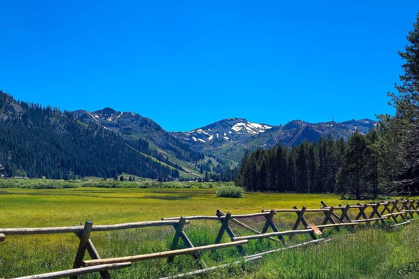 Een prachtig uitzicht op een berglandschap, met een houten hek op de voorgrond.