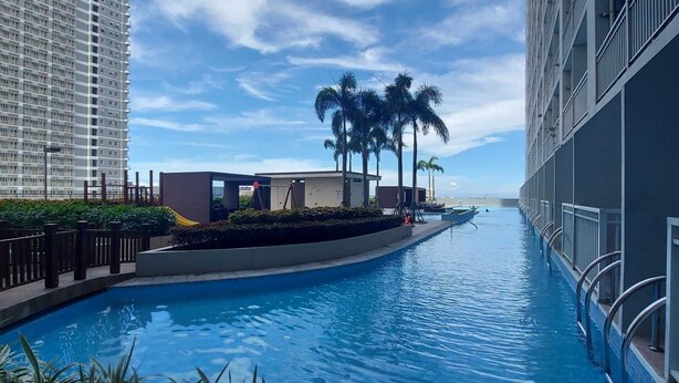 Una piscina con vistas a edificios altos y palmeras.