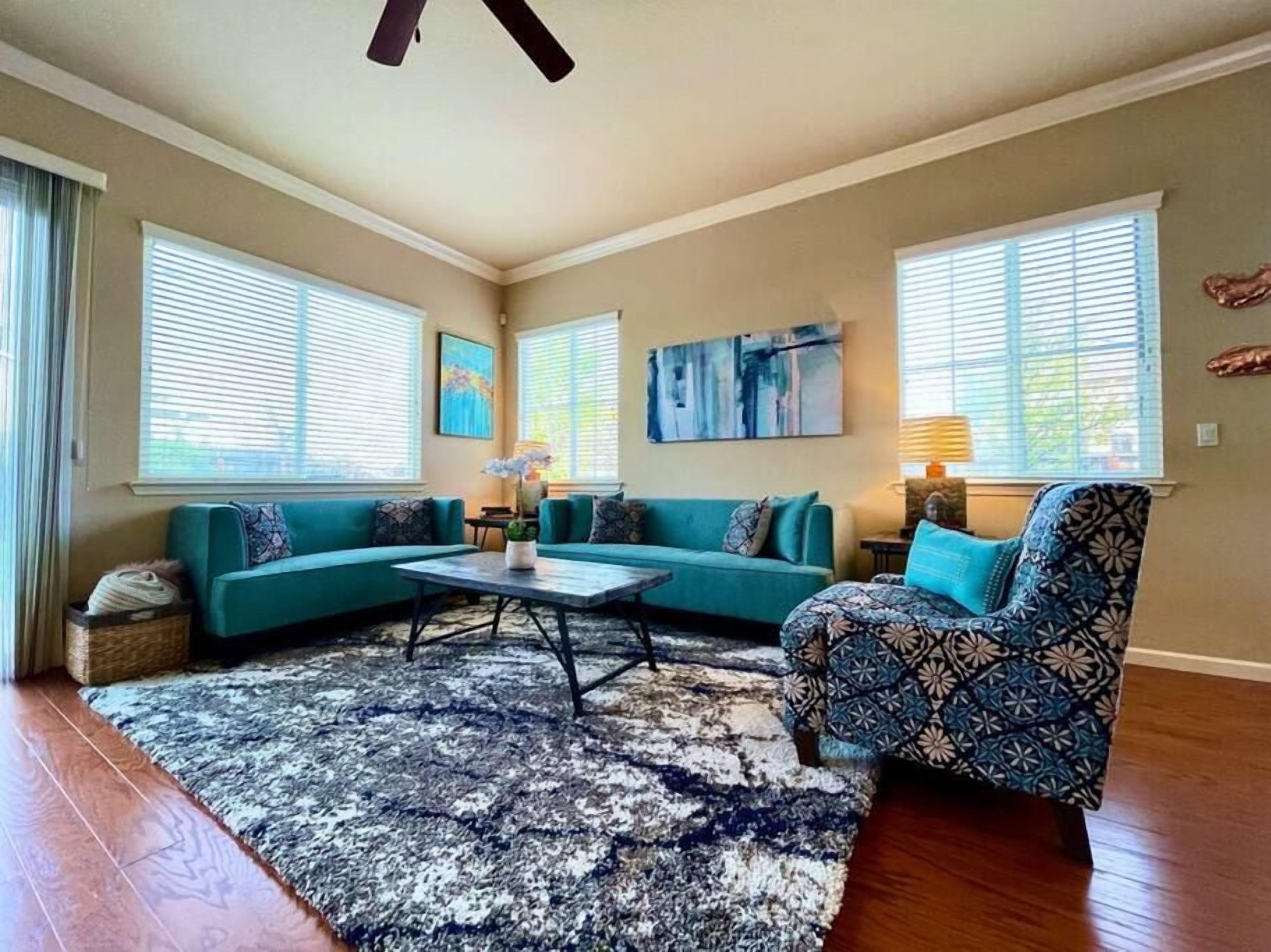 Una sala de estar con un sofá modular, un sillón estampado y una mesa de centro.