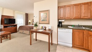 A hotel room with a bed, a desk, a television, a coffee maker, and a dishwasher. - Free Daily Breakfast, Pool + Hot Tub Access (Albuquerque)