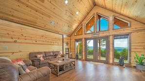 A spacious living room with a wooden ceiling, large windows, and a view of the outdoors. - Log Cabin with Million Dollar View! “The Time Out” Secluded property (tuskahoma)