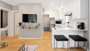 A modern kitchen with white cabinets, a built-in microwave, and a hanging light fixture. - Beautiful Modern home peaceful location (Alberta Beach)