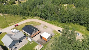 An aerial view of a residential area with a large house, a smaller attached building, and a fenced yard. - Beautiful Modern home peaceful location (Alberta Beach)