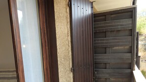Un balcón con puerta corredera y vistas al exterior.