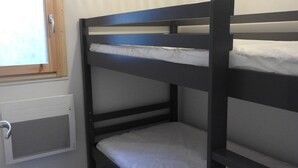 Una cama litera con ventana y lámpara en el techo.