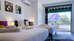 Une chambre d’hôtel avec deux lits, une grande fenêtre et une vue sur une montagne.