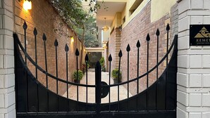 A gated entrance to a hotel with a brick facade and a sign for 'KEMET Boutique Hotel'. - Kemet Boutique Hotel (Giza)