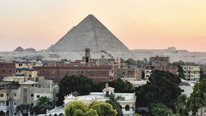 A view of a pyramid in the background with a cityscape in the foreground. - Kemet Boutique Hotel (Giza)