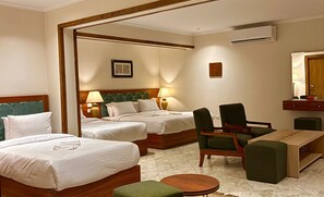 A hotel room with two beds, a desk, a chair, and a small round table. - Kemet Boutique Hotel (Giza)