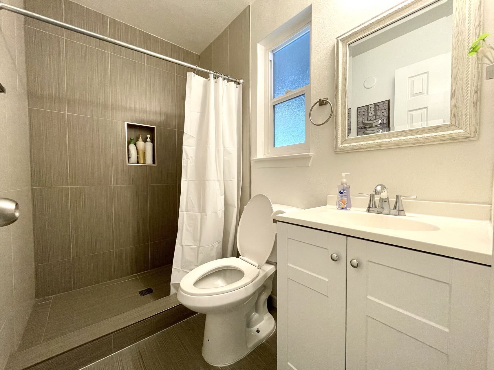 Une salle de bain avec douche, toilettes et lavabo.