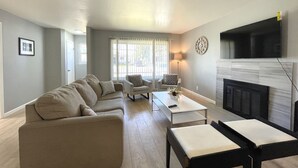 Una sala de estar moderna con sofá, sillones, una mesa de centro y una chimenea.
