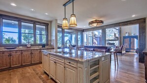 Una cocina amplia con una isla grande, armarios de madera e iluminación colgante.
