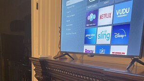 A fireplace with a TV mounted above it displaying streaming services. - Fireplace and Farmers Market Cozy! (Dubuque)