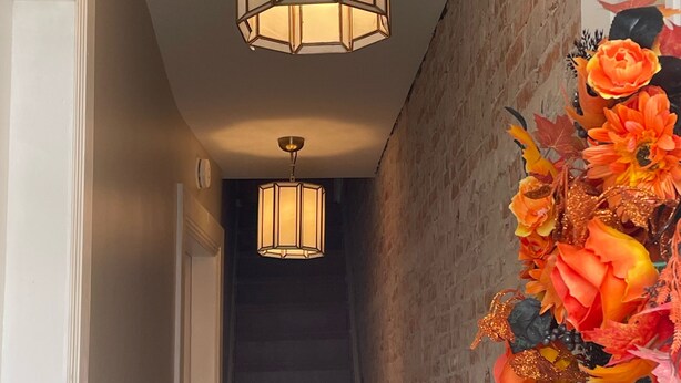 A staircase with a brick wall on one side and a white door on the other. - Fireplace and Farmers Market Cozy! (Dubuque)