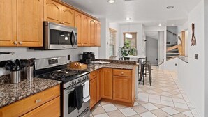 A kitchen with wooden cabinets, a stainless steel microwave, granite countertops, a gas stove, and a sink. - 𖤓GrandVictorian 5000sqft Sale Sleeps23 ArcadeGameFloor BBQ𖤓 (Milwaukee)