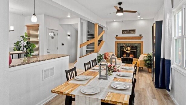 A modern dining area with a wooden table set for six, a staircase, and a fireplace. - 𖤓GrandVictorian 5000sqft Sale Sleeps23 ArcadeGameFloor BBQ𖤓 (Milwaukee)