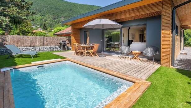A modern house with a swimming pool, wooden deck, and outdoor furniture. - Maison BOOA 4* - Private swimming pool & Lake nearby (Sévrier)
