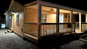 Une cabane en bois avec un porche et une entrée couverte.