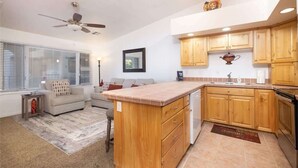 A compact living space with a kitchenette, a ceiling fan, a sofa, and a dining area. - Las Palmas Resort #1638 | All-Inclusive Amenities (Saint George)