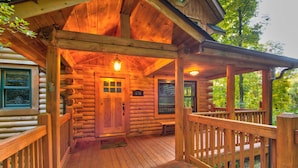 A log cabin with a wooden porch, a front door, and a number sign '670'. - Hideaway Homestead - Private 3BR home between Boone/ Banner Elk! Pet friendly, excellent location! (Banner Elk)