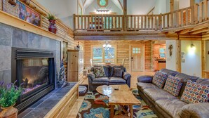 A spacious log cabin interior with a fireplace, a wooden balcony, and a cozy seating area. - Hideaway Homestead - Private 3BR home between Boone/ Banner Elk! Pet friendly, excellent location! (Banner Elk)