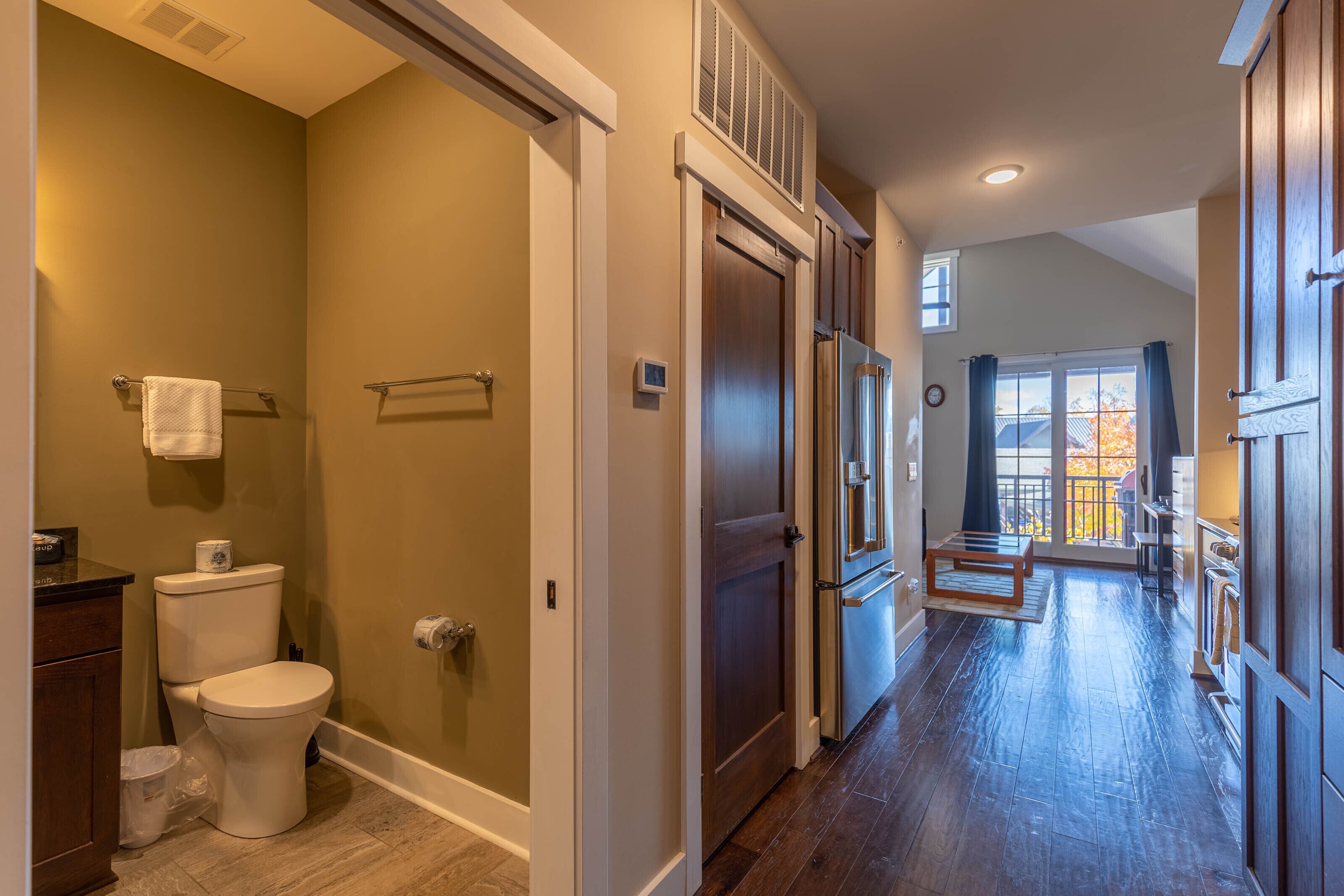A modern bathroom with a toilet, a shower, and a built-in sink.