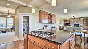 A spacious kitchen with wooden cabinets, a central island, and pendant lighting. - Incredible Oregon Retreat w/ Private Hot Tub! (The Dalles)