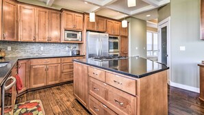 A modern kitchen with wooden cabinets, stainless steel appliances, and a large island. - Incredible Oregon Retreat w/ Private Hot Tub! (The Dalles)