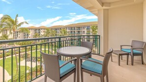 A balcony with wicker furniture and a view of a resort complex. - Maui Resort Rentals: Westin Ka'anapali Ocean Resort North Studio Islandview Villa (Lahaina)